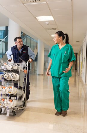 Technicien Air Liquide livrant des bouteilles de gaz médicaux avec une professionnelle de santé
