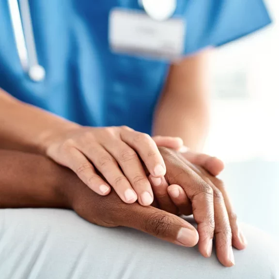 Une médecin prenant les mains d'un patient